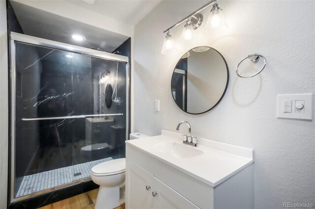 2204 Reed Grass Way, Colorado Springs, CO 80915 - full bathroom featuring toilet, vanity, a stall shower, and wood finished floors