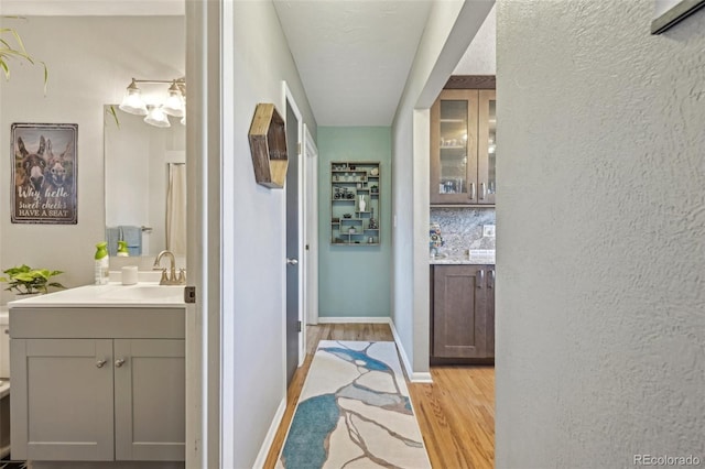 hallway featuring sink and light hardwood / wood-style flooring