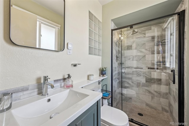 bathroom with vanity, a shower with shower door, and toilet