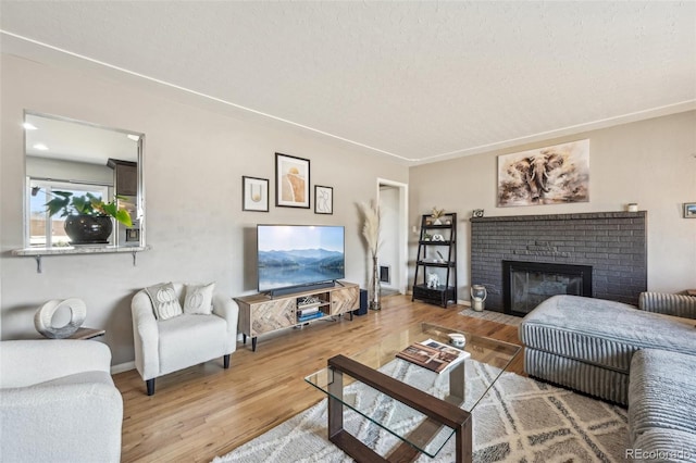 living room with wood-type flooring, a textured ceiling, and a fireplace