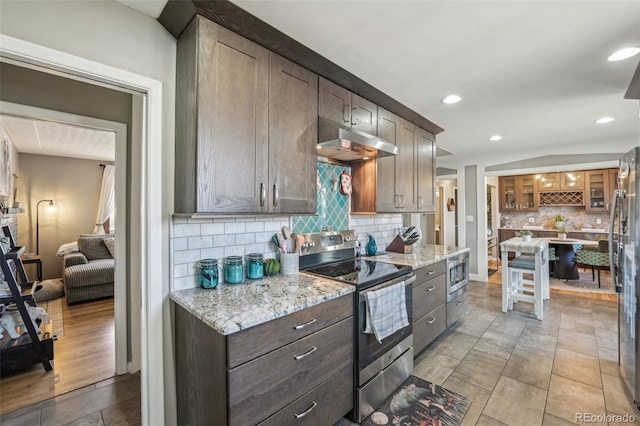 kitchen with light stone counters, dark brown cabinets, appliances with stainless steel finishes, and tasteful backsplash