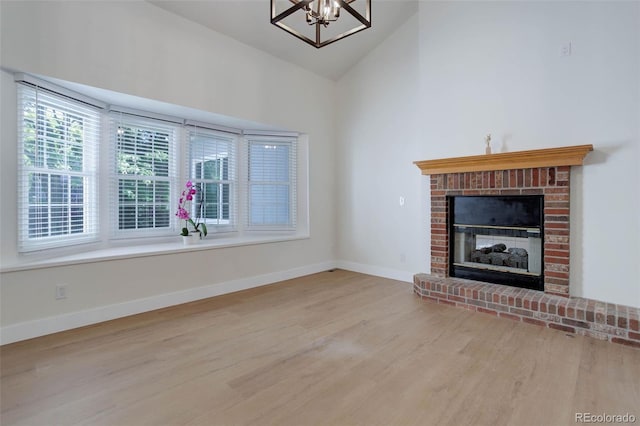 6055 W Warren, Lakewood, CO 80227 - unfurnished living room with wood finished floors, a fireplace, a chandelier, and high vaulted ceiling