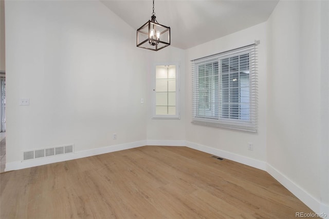 6055 W Warren, Lakewood, CO 80227 - unfurnished dining area featuring a chandelier, light wood-style flooring, and vaulted ceiling