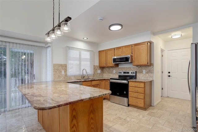 6055 W Warren, Lakewood, CO 80227 - kitchen featuring appliances with stainless steel finishes, a peninsula, hanging light fixtures, backsplash, and light stone countertops