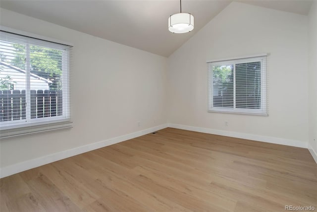 6055 W Warren, Lakewood, CO 80227 - spare room featuring plenty of natural light, light wood finished floors, and vaulted ceiling