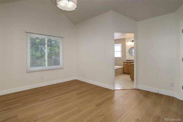 6055 W Warren, Lakewood, CO 80227 - empty room featuring healthy amount of natural light, light wood-type flooring, and high vaulted ceiling