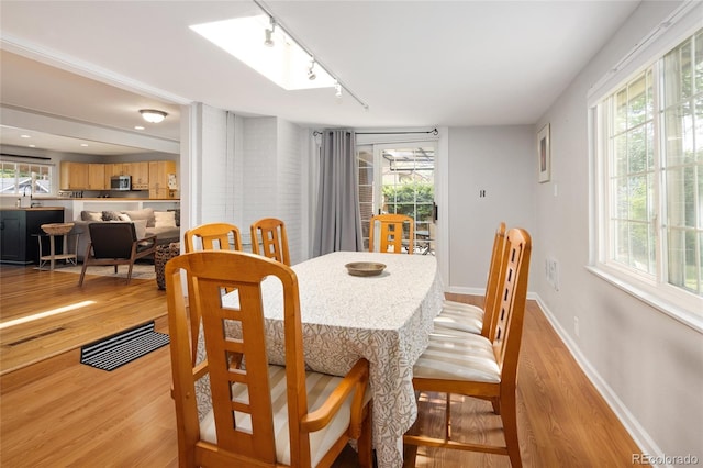 745 S Glencoe St, Denver, CO 80246 - dining space with rail lighting, light wood finished floors, and healthy amount of natural light