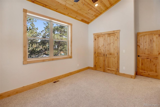 unfurnished bedroom featuring ceiling fan, wooden ceiling, carpet floors, and vaulted ceiling