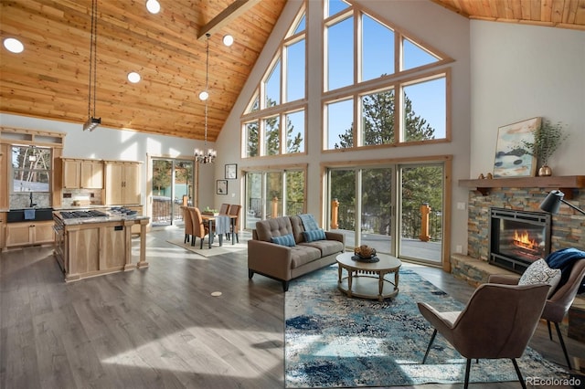 living room featuring high vaulted ceiling, a stone fireplace, beamed ceiling, light hardwood / wood-style floors, and wood ceiling