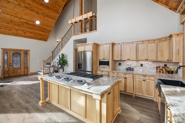 kitchen featuring light stone countertops, stainless steel appliances, high vaulted ceiling, wooden ceiling, and a center island