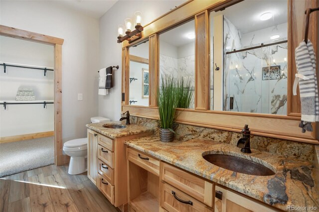 bathroom featuring wood-type flooring, vanity, toilet, and an enclosed shower