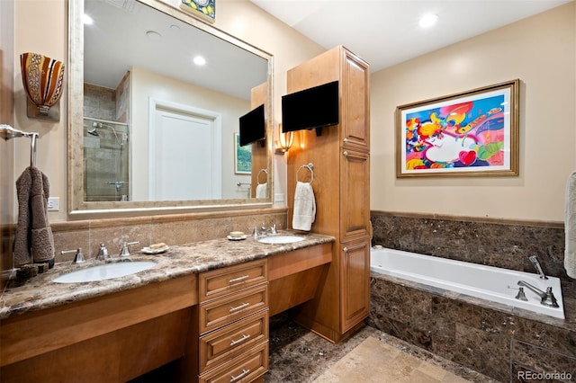 bathroom with double vanity, a sink, a bath, and a shower stall