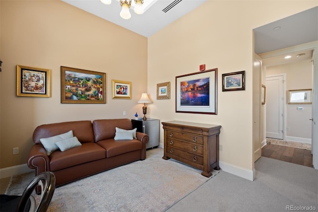 living room with baseboards, visible vents, and light colored carpet