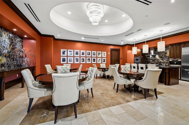 dining room featuring visible vents, a tray ceiling, and crown molding