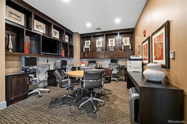 carpeted home office featuring visible vents and built in desk