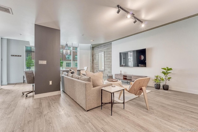 1700 Bassett St Unit 101, Denver, CO 80202 - living room with rail lighting, light wood-style flooring, and baseboards