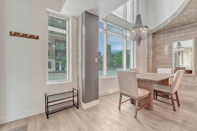 1700 Bassett St Unit 101, Denver, CO 80202 - dining space with a chandelier, light wood-style floors, and baseboards