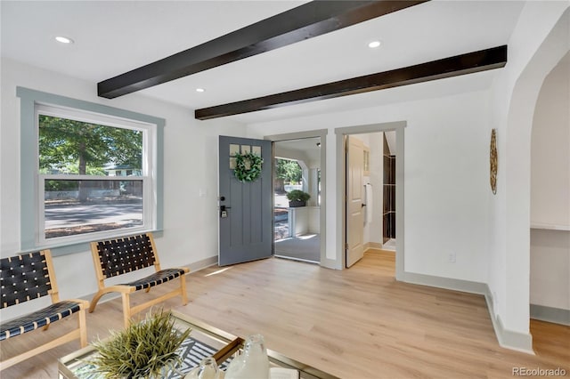 foyer entrance with beamed ceiling and light hardwood / wood-style floors