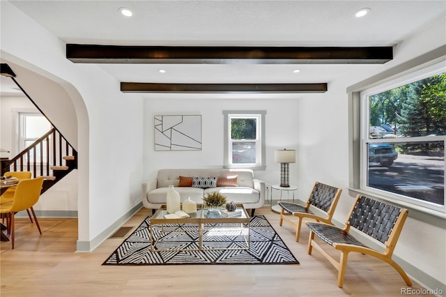 living room with light wood-type flooring and beam ceiling