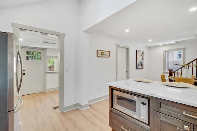 kitchen featuring light hardwood / wood-style flooring, appliances with stainless steel finishes, and light stone countertops