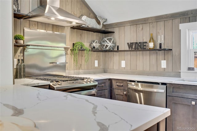 kitchen featuring ventilation hood, light stone countertops, and appliances with stainless steel finishes