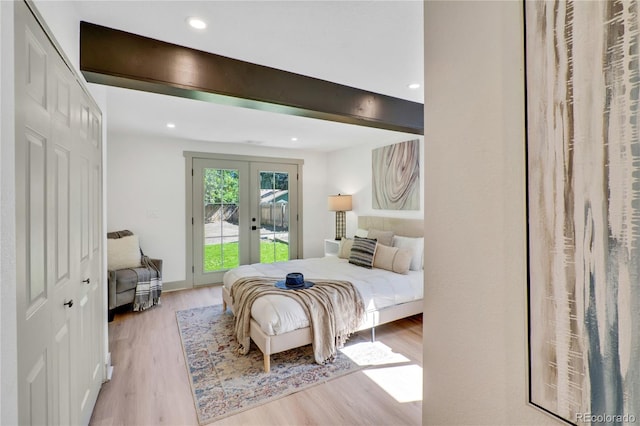 bedroom featuring a closet, light hardwood / wood-style floors, french doors, and access to exterior