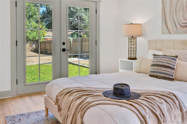 bedroom with access to outside, hardwood / wood-style floors, and french doors