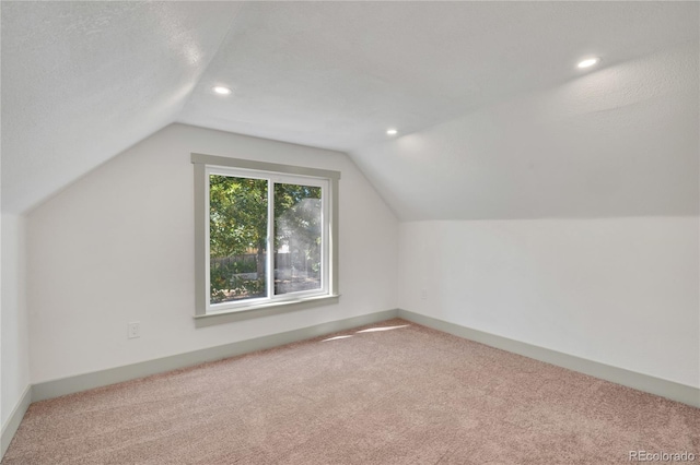 bonus room featuring a textured ceiling, carpet, and lofted ceiling