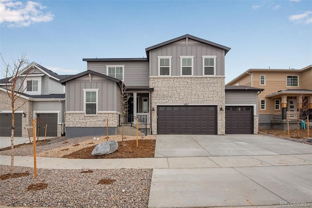 3452 N Gold Bug Ct, Aurora, CO 80019 - view of front facade with board and batten siding, stone siding, concrete driveway, and a garage