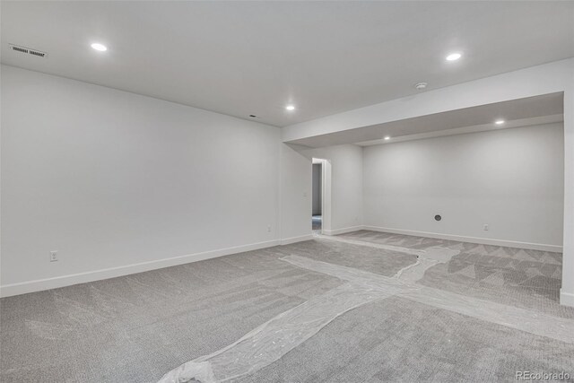 basement featuring light carpet