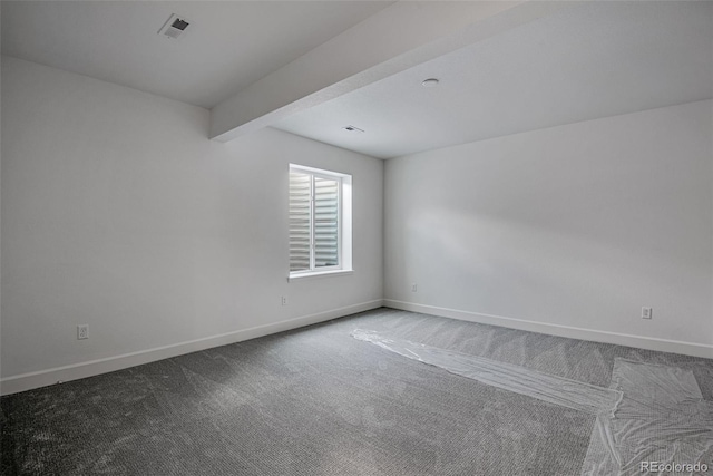 carpeted empty room with beam ceiling