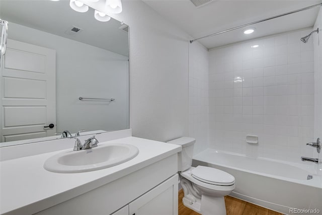 full bathroom featuring vanity, toilet, tiled shower / bath combo, and hardwood / wood-style floors