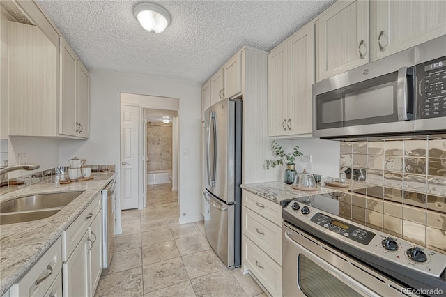 4800 E Hale Pkwy Unit 802N, Denver, CO 80220 - kitchen featuring stainless steel appliances, a sink, a textured ceiling, baseboards, and light stone countertops