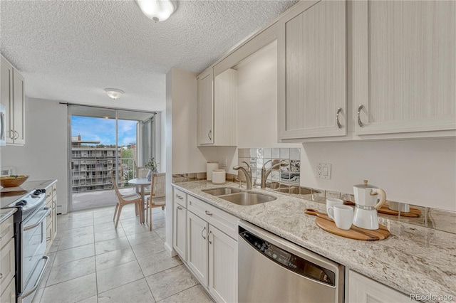 4800 E Hale Pkwy Unit 802N, Denver, CO 80220 - kitchen featuring stainless steel appliances, a sink, a textured ceiling, light stone counters, and light tile patterned floors