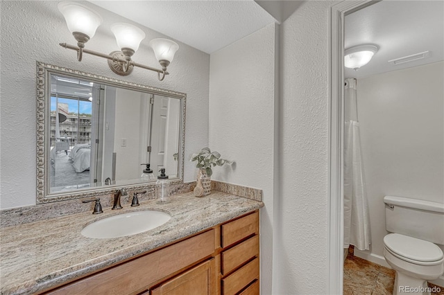 4800 E Hale Pkwy Unit 802N, Denver, CO 80220 - bathroom featuring toilet, vanity, and a textured wall
