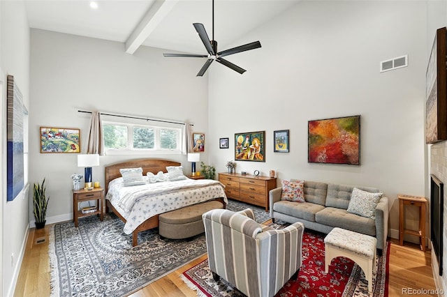 2635 Pierce St, Wheat Ridge, CO 80214 - bedroom featuring high vaulted ceiling, wood finished floors, beamed ceiling, a fireplace, and a ceiling fan