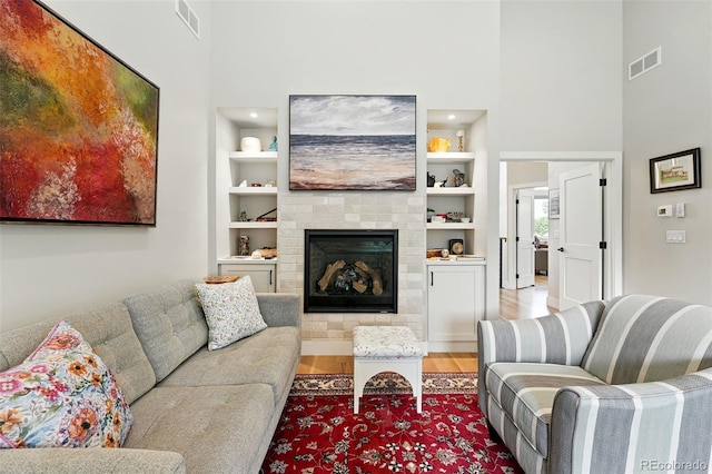 2635 Pierce St, Wheat Ridge, CO 80214 - living area with a towering ceiling, wood finished floors, a fireplace, and built in shelves