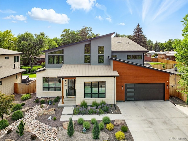 2635 Pierce St, Wheat Ridge, CO 80214 - contemporary home featuring a standing seam roof, brick siding, driveway, a metal roof, and a garage