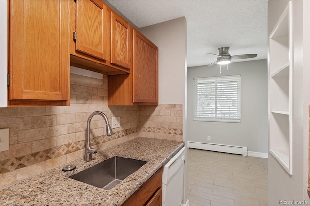 kitchen with dishwasher, light stone counters, sink, a baseboard radiator, and ceiling fan