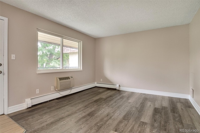 spare room featuring a textured ceiling, dark wood-type flooring, and a baseboard heating unit