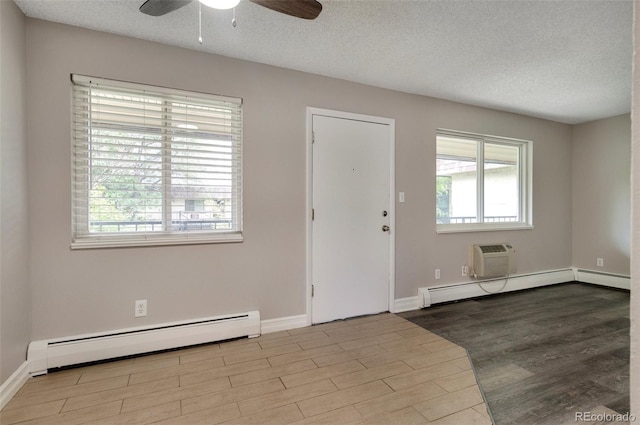 foyer entrance featuring ceiling fan, a textured ceiling, light hardwood / wood-style floors, and a baseboard heating unit