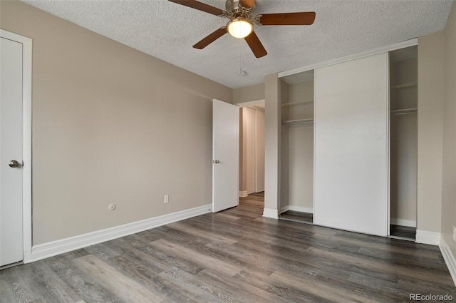 unfurnished bedroom featuring ceiling fan, a textured ceiling, and dark wood-type flooring