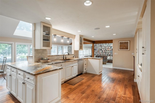 7750 S Glencoe Way, Centennial, CO 80122 - kitchen featuring dishwasher, a peninsula, glass insert cabinets, light wood-style floors, and recessed lighting