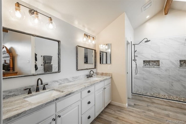 7750 S Glencoe Way, Centennial, CO 80122 - bathroom featuring double vanity, a tile shower, and wood finished floors