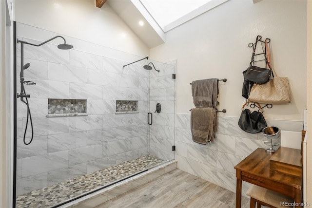 7750 S Glencoe Way, Centennial, CO 80122 - full bathroom featuring a skylight, a shower stall, lofted ceiling, tile walls, and wainscoting