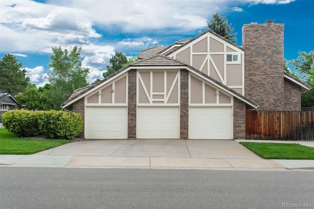7750 S Glencoe Way, Centennial, CO 80122 - tudor home with concrete driveway, brick siding, stucco siding, a tile roof, and an attached garage