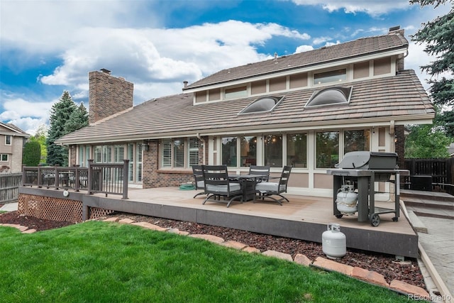 7750 S Glencoe Way, Centennial, CO 80122 - back of property with a chimney, a deck, a tiled roof, brick siding, and outdoor dining area