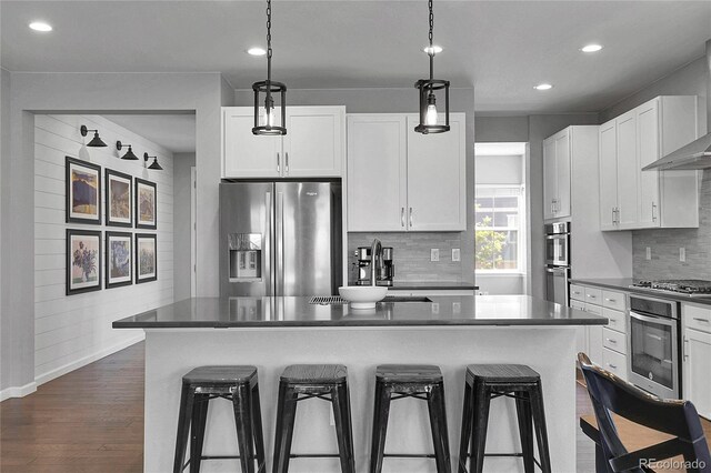 4781 Basalt Ridge Cir, Castle Rock, CO 80108 - kitchen with stainless steel appliances, a breakfast bar, dark countertops, and recessed lighting
