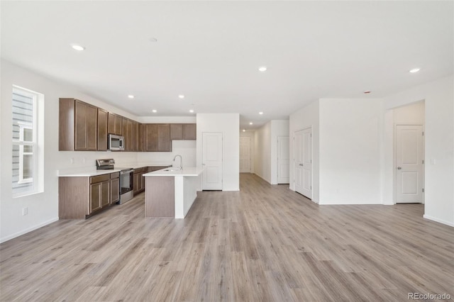 13392 E 110th Way, Commerce City, CO 80022 - kitchen with appliances with stainless steel finishes, a sink, open floor plan, light wood-style floors, and recessed lighting