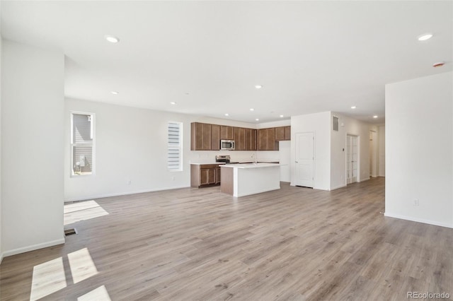13392 E 110th Way, Commerce City, CO 80022 - unfurnished living room featuring recessed lighting, light wood finished floors, baseboards, and a sink